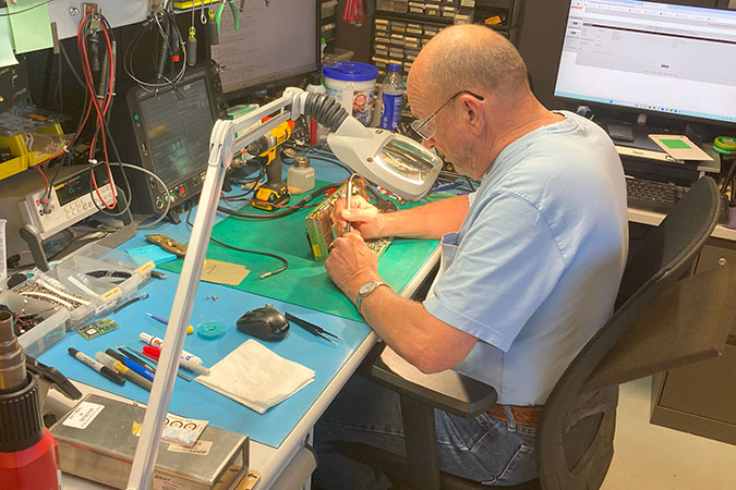 Robert Peterson, electronic technician II, tests a circuit board. Robert Peterson, electronic technician II, tests a circuit board.