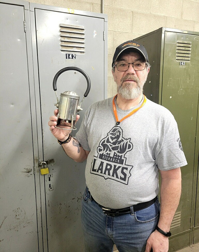 Jeff Kessel standing in front of his locker at work, holding his father’s 30-year-old carman lantern Jeff Kessel standing in front of his locker at work, holding his father’s 30-year-old carman lantern