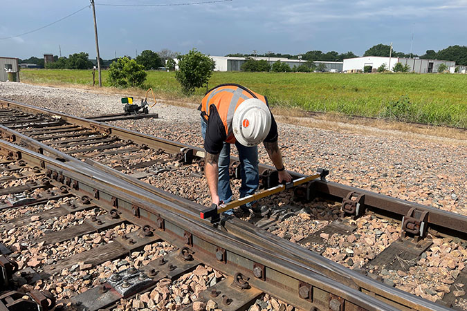Cunningham measuring the distance between the rails using a track gauge Cunningham measuring the distance between the rails using a track gauge