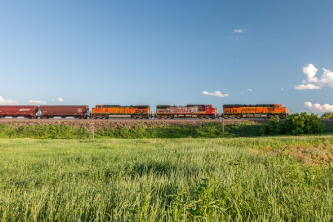A BNSF train moves bulk sugar in covered hopper cars. A BNSF train moves bulk sugar in covered hopper cars.